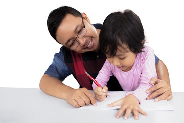 Young father teaching his daughter to write