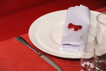 Decoration of the festive table. Elements of decor. Beautiful dishes on a red tablecloth
