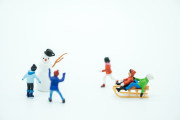 Snowman miniature toy and children people figure playing around. Seasonal, Kid and family concept.