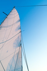 Fototapeta premium Part of hoisted mainsail of sailboat against blue sky