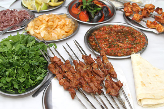 Turkish shish kebab with various salads and grilled vegetables