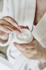 Frau mit schminktigel in der Hand 