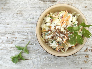 Coleslaw salad with purple carrots and cilantro in a bowl