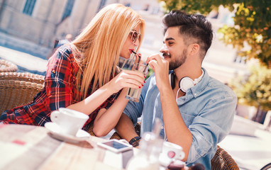 Romantic couple drinking coffee and lemonade, having a date in the cafe. Dating, love, relationships