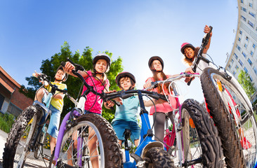 Obraz premium Happy little bike riders standing against blue sky