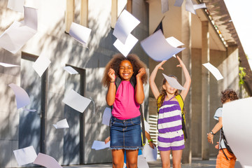 Very happy girl smiling throwing papers in the air