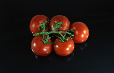 Red tomatoes on the isolated black background