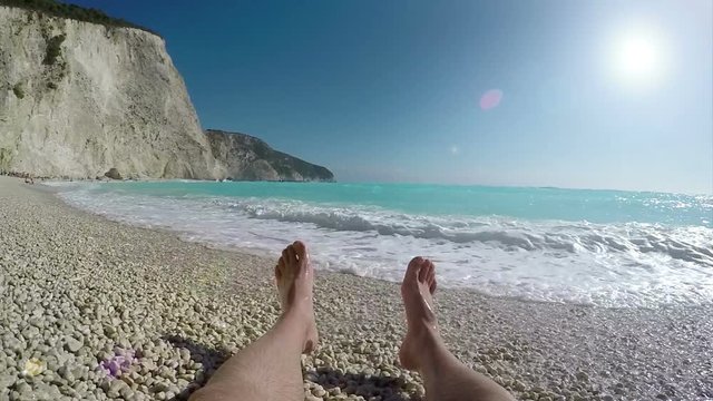 Porto Katsiki beach on the Ionian island of Lefkada, Greece. Man sunbathe and enjoy on vacation. The beach is famed for its landscape and clear blue sea, slow motion