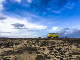 Classic yellow camper van standing in the outback of Fuerteventura in the early morning light.