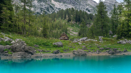 Panoramic view of the mountain hut in Triglav Lakes Valley with green forest and high mountains in...