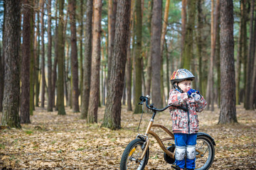 Naklejka premium Young boy with bicycle with drinking clear water