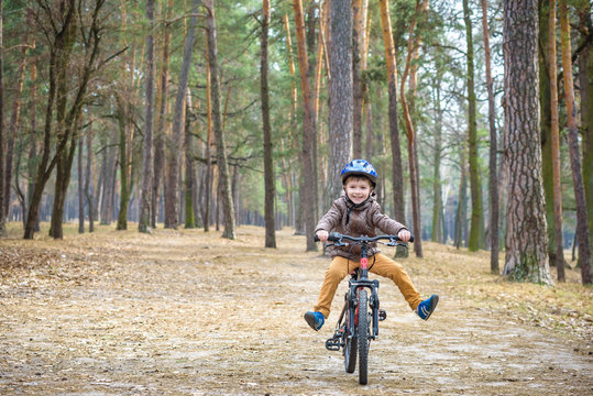 Happy Kid Boy Of 3 Or 5 Years Having Fun In Autumn Forest With A Bicycle On Beautiful Fall Day. Active Child Wearing Bike Helmet. Safety, Sports, Leisure With Kids Concept.