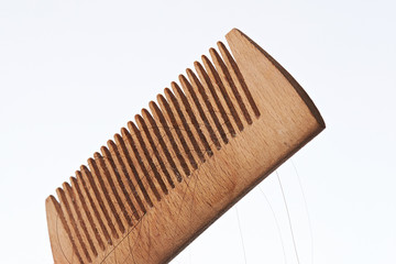 Wooden comb with dark hair strands