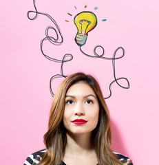 Light Bulb with young woman on a pink background