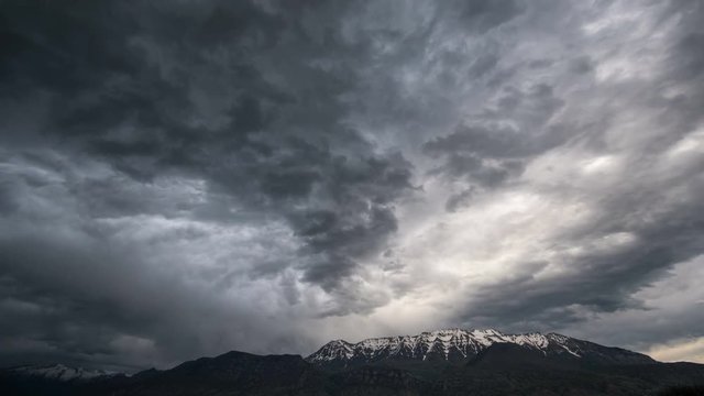 Moody clouds moving towards mountain top in time lapse