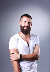 Portrait of handsome man standing, isolated on grey background