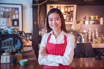 Beautiful asian coffee shop owner standing and smiles in her shop