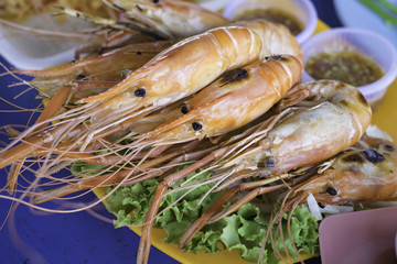 Grilled shrimps on plate with spicy sauce.