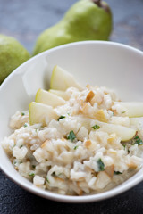 Close-up of risotto with pears, cheese and parsley, selective focus, studio shot