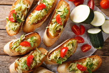 Bruschetta with grated zucchini and tomatoes close-up and ingredients. horizontal top view
