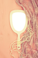 Top view image of vintage hand mirror and delicate female romantic scarf