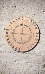 The governors island, outlook hill elevation marker embedded in stone in new york City.