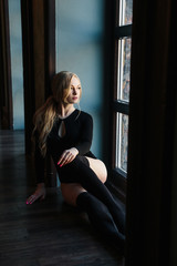 Young blonde woman with perfect body wears bodysuit