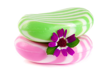 Two multi-colored striped soaps with a flower isolated on white background