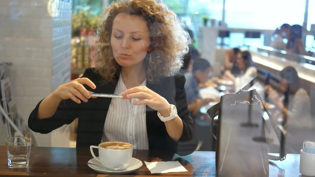 Young Woman Taking Photograph Of Coffee In Cafe. 4K. 