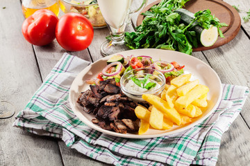 Grilled meat with French fries and fresh vegetables
