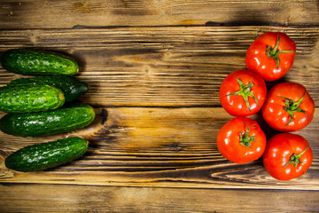 Fresh tomatoes and cucumbers on wooden table