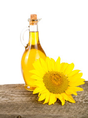 Sunflower oil and flower on wooden table with white background