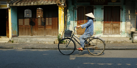 Fototapeta na wymiar riding bicycle in the street of hoi an in vietnam