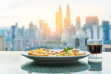 Breakfast with coffee behind skyscraper view in morning, Malaysia.