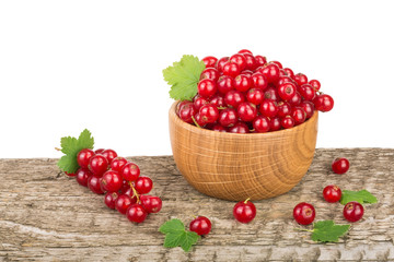 Fototapeta na wymiar Red currant berries in wooden bowl on wooden table with white background