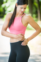 Fototapeta premium sport woman back pain in a park in summer