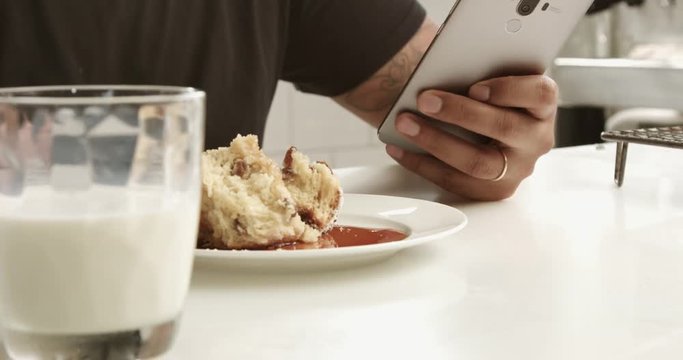 closeup of mixed race man's hand texting in smartphone during breakfast