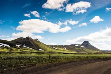 Landmannalaugar, highland landscape in summer in Iceland with aview of green mountain, cloud and contrast with blue sky.