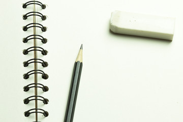 Closu up pencil and eraser over blank notepad, copy space