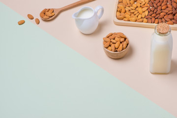 Almonds and milk bottle on light background. Almond nuts in spoon.