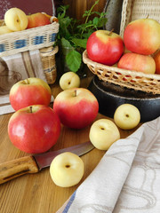 Apples and white nectarines on a wooden table and in wicker baskets. Fresh harvest