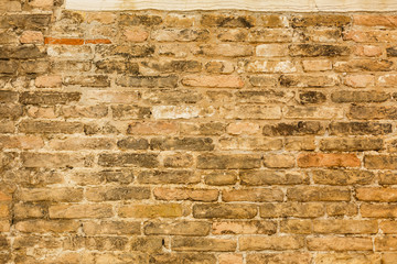 Old brick wall with cracks and scratches. Horizontal wide brickwall background. Distressed wall with broken bricks texture. House facade. Vintage filter.