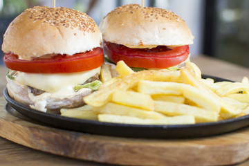Delicious burgers with beef, tomato, cheese, and lettuce. Beautiful and tasty meal at the restaurant.