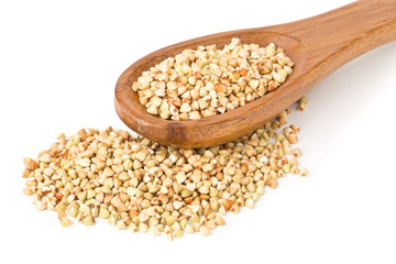 Raw, natural, uncooked buckwheat seed kernels in wooden spoon