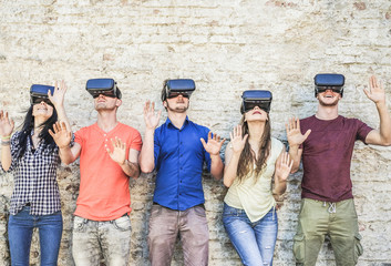 Young friends playing with virtual reality glasses outdoor - Young people having fun with new technology vr headset - Main focus on goggles glasses- New generation digital mania trends - Retro filter