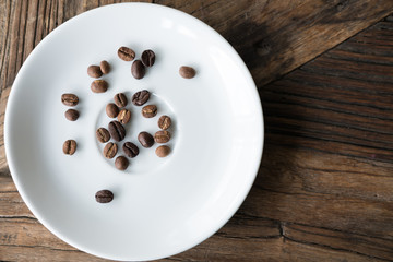 coffee bean on white saucer on wood table