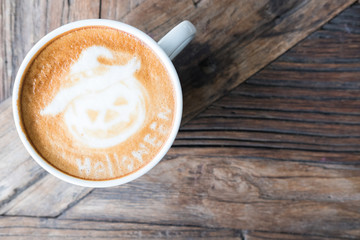 halloween latte art on hot cappuccino coffee in white mug on wood table