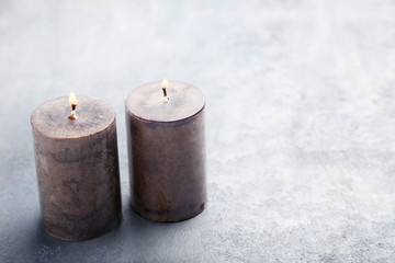 Fototapeta na wymiar Burning candles on the grey table