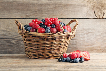 Ripe and sweet berries in basket on wooden table © 5second