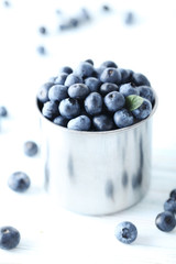 Ripe and tasty blueberries on blue wooden table